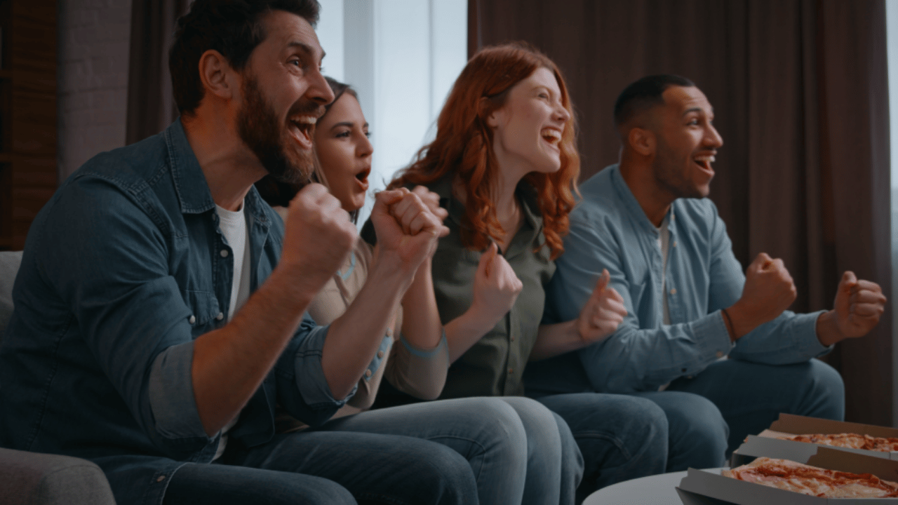 Friends celebrate together in front of the TV