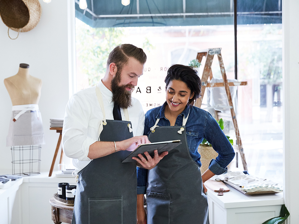 Small business owners in a retail shop discussing business operations, energy management and customer experience.