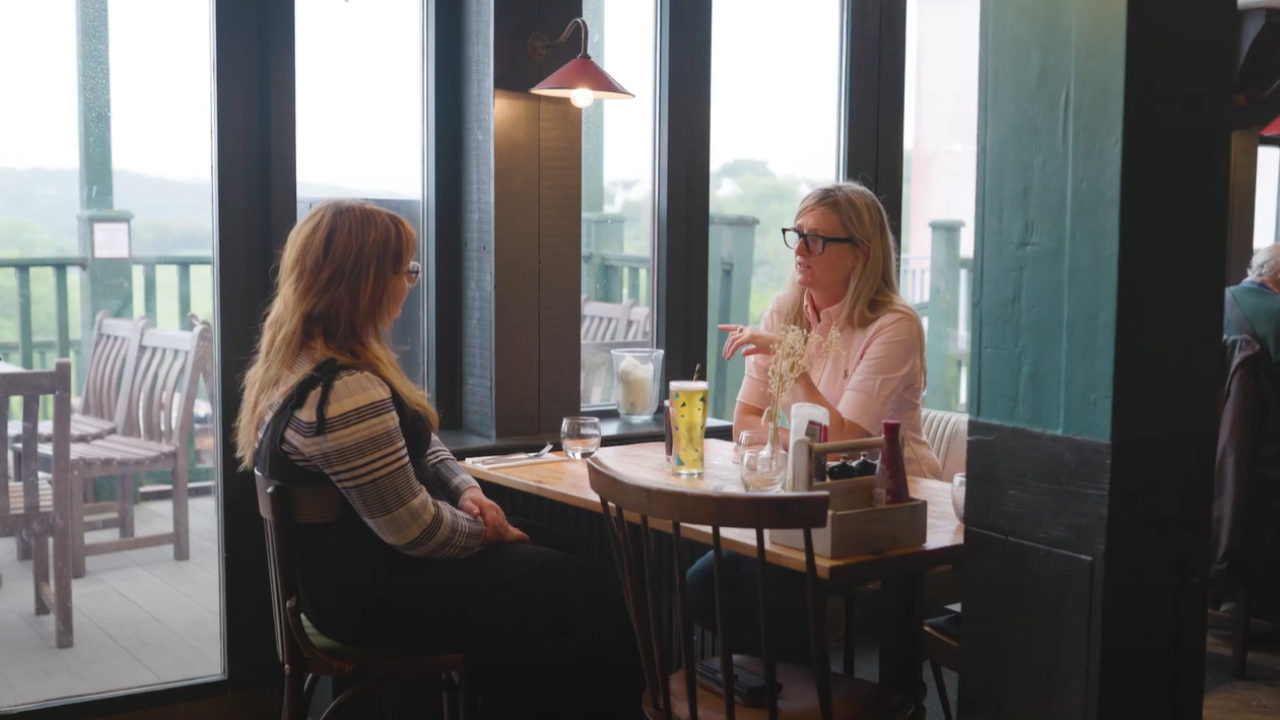 Two people meeting in a café to discuss services and customer needs, illustrating community engagement, customer experience and local business relationships.