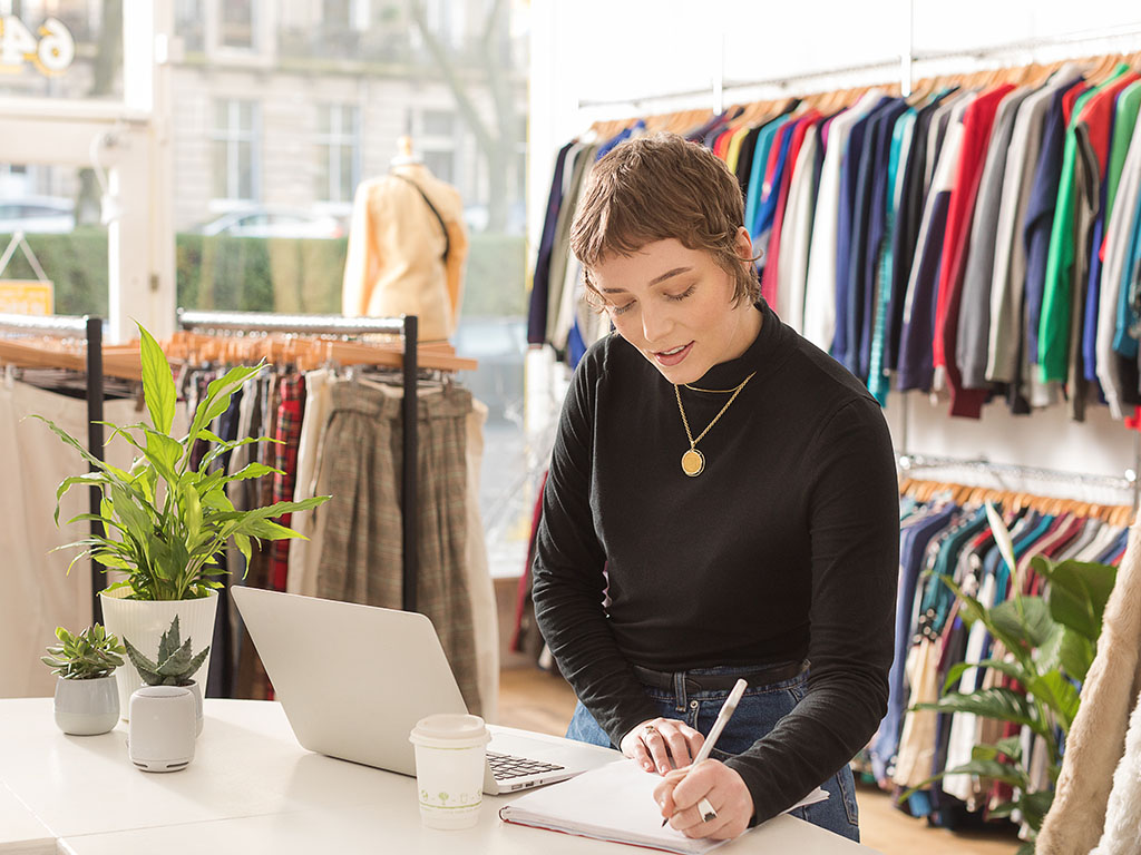 Woman in shop writing notes