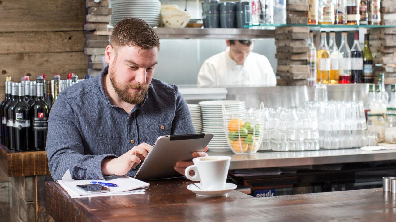 man sitting in a cafe using his tablet