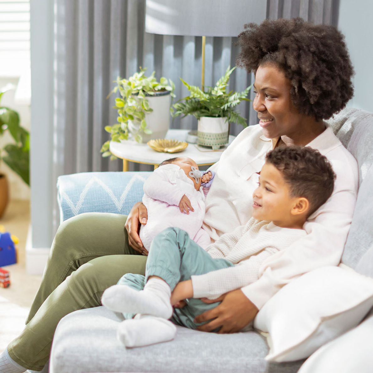 a mother sitting on a sofa with two children