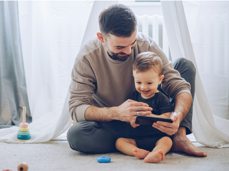 A father showing his child something on a phone screen