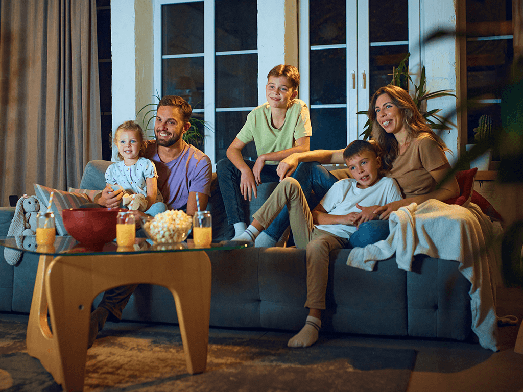 family sitting on the couch watching the television