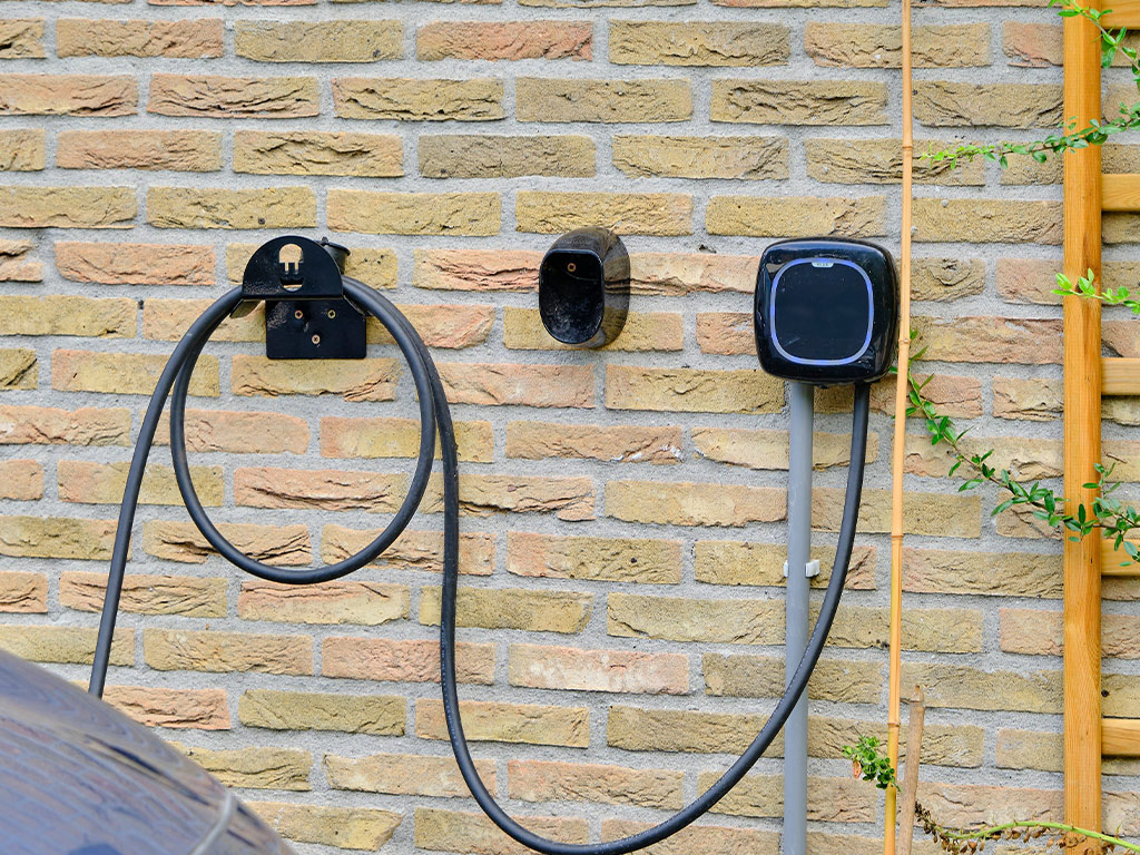 Black wall box EV charger attached to brick wall