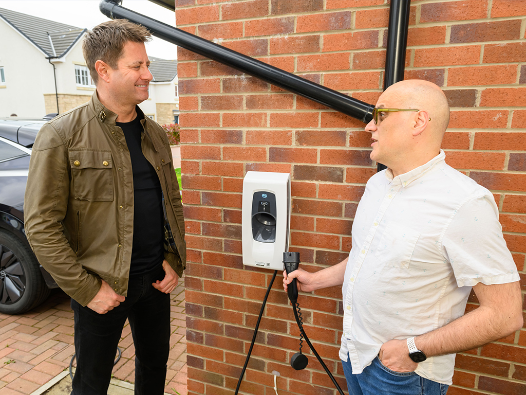 George speaking to a ScottishPower customer about EV charging in front of a home EV charger