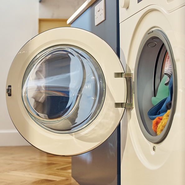 Open washing machine with colourful clothing inside