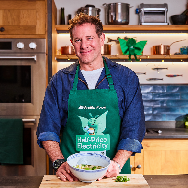 TV Chef Matt Tebbutt smiling wearing Bruce apron holding a bowl of festive turkey wonton dumplings.