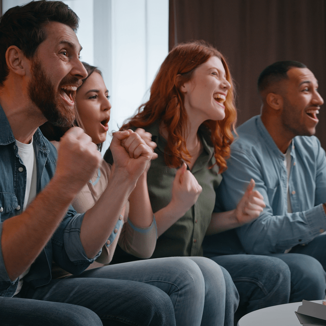Friends celebrate in front of TV - Goalkeeper in front of goal with goalie gloves - family settles in to watch football game in front of the TV