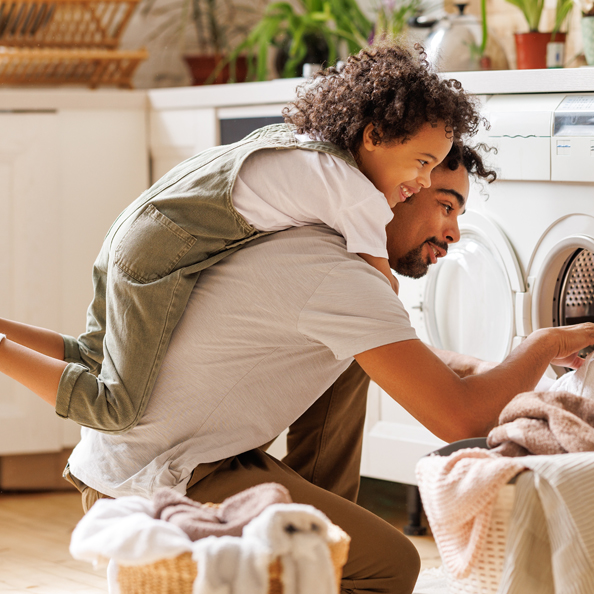 Father and son loading the washing machine