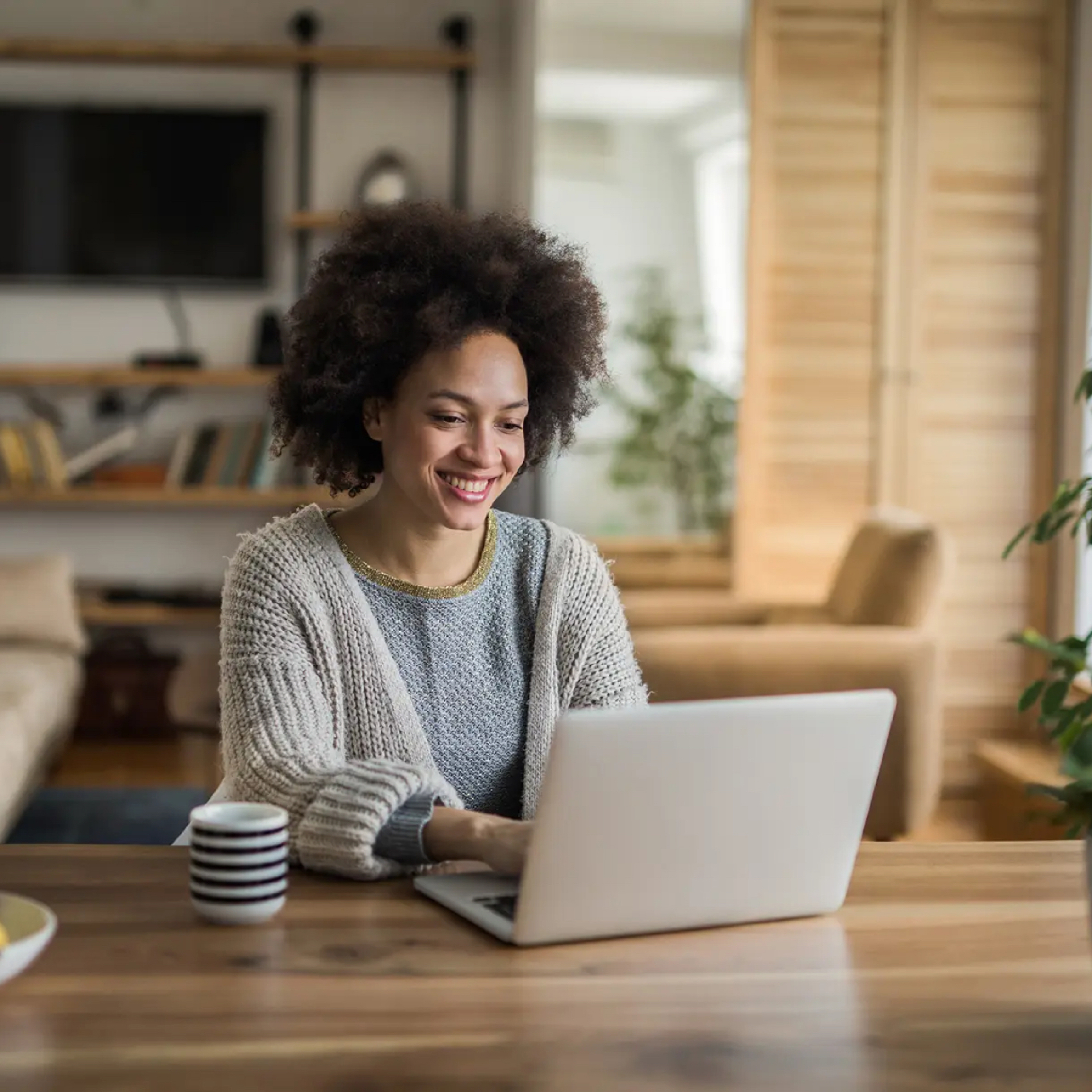 Woman sits at table with her laptop