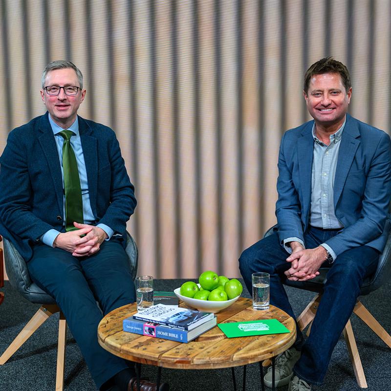George Clarke and Andrew Ward sitting at table, smiling at camera. 