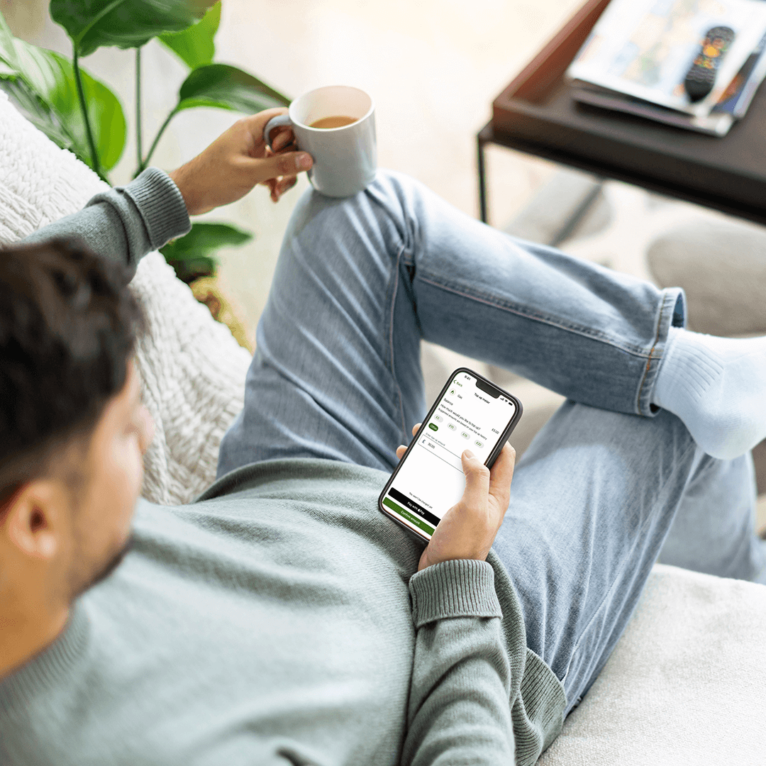 man holding phone looking at SP app for top up