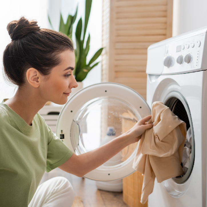 Women putting clothes in the washing machine
